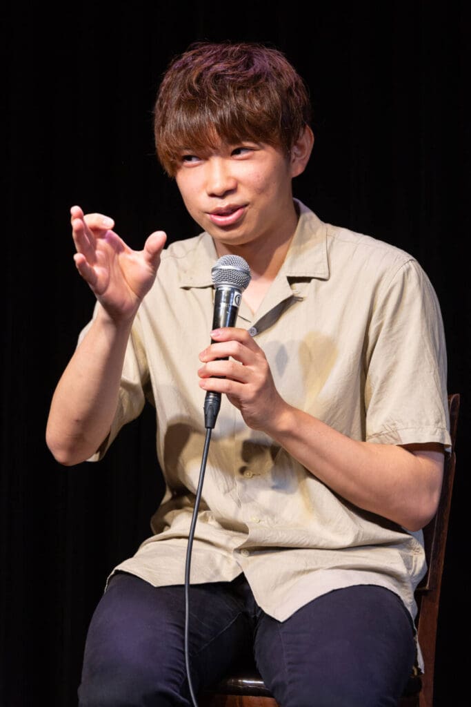 Headshot of a man speaking politely in a mic with the audience at the Symposium for a movie - Tokyo Portrait Photographer