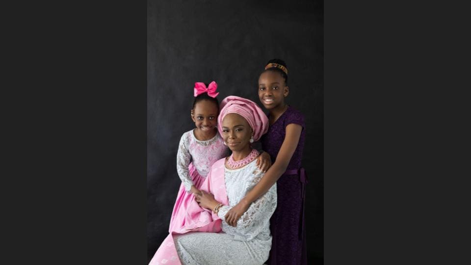 A mother with her two daughters, all in fancy unique dresses posing the camera - family photography, lifestyle photography